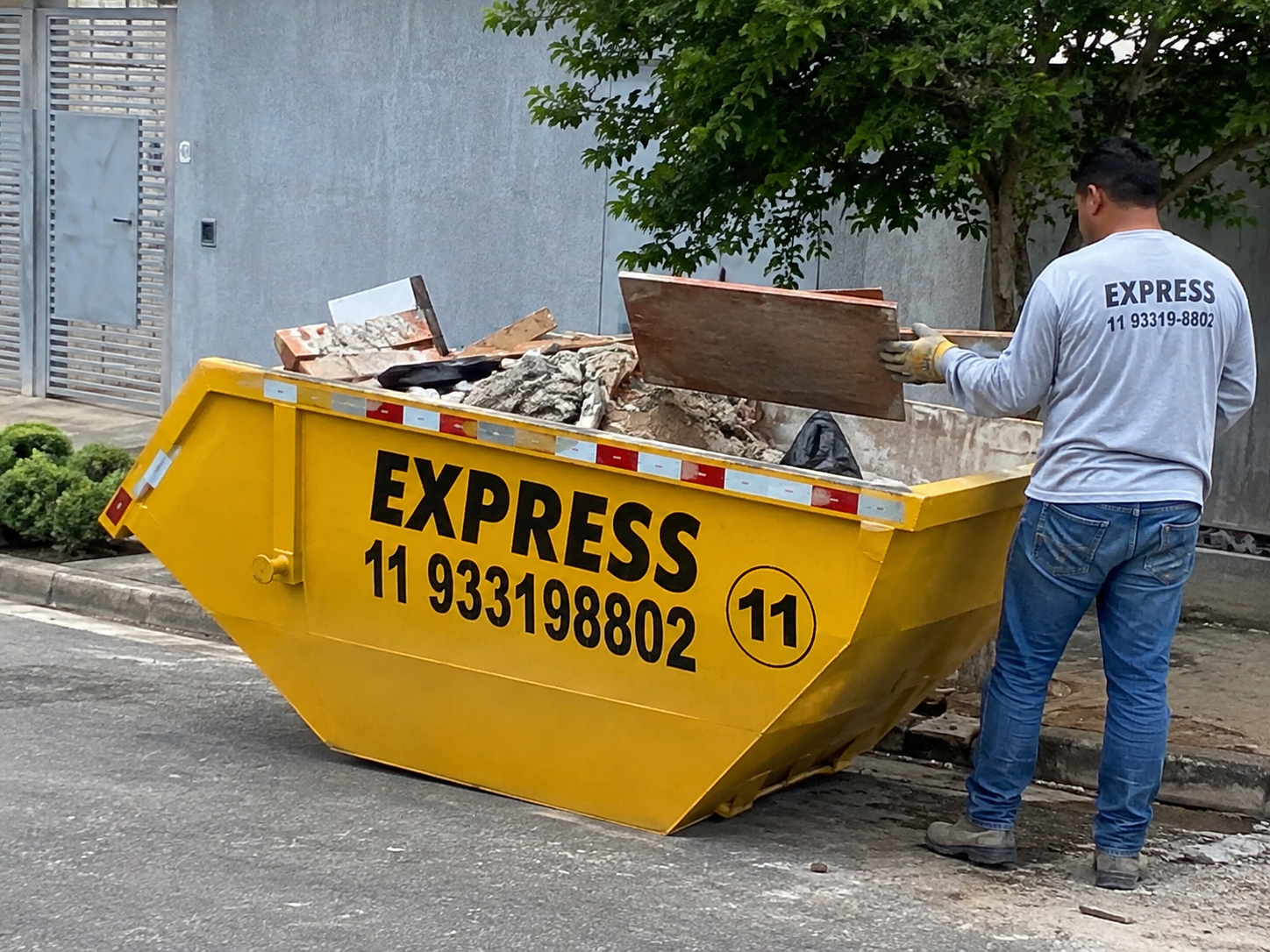 Caçamba amarela da Caçamba Express cheia de entulho
