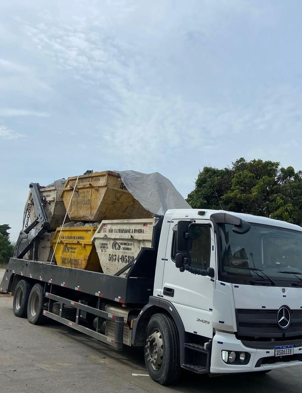Caminhão carregado com caçambas para retirada de entulho